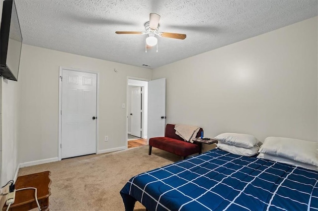 carpeted bedroom with a textured ceiling and ceiling fan