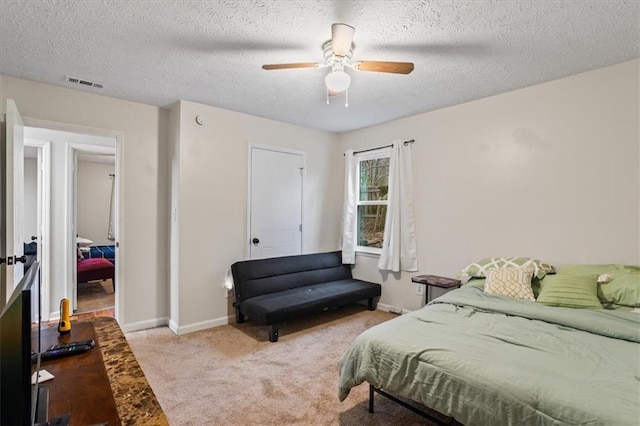 bedroom with light colored carpet, a textured ceiling, and ceiling fan