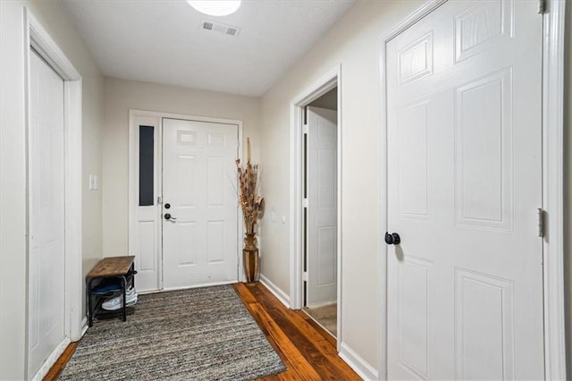 doorway with dark wood-type flooring