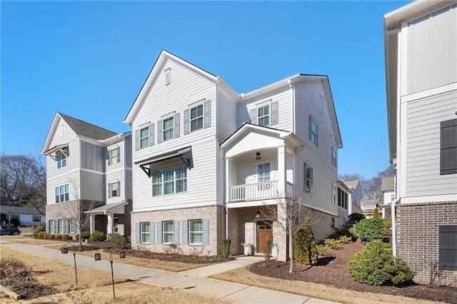 townhome / multi-family property with stone siding, a residential view, and board and batten siding