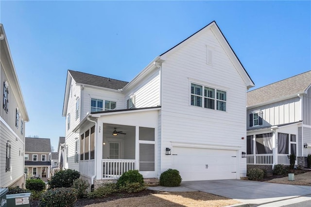 traditional-style home featuring driveway, a sunroom, and a garage