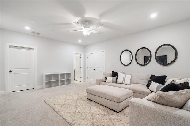 carpeted living room with ceiling fan, visible vents, baseboards, and recessed lighting