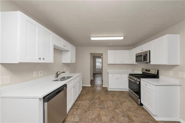 kitchen featuring white cabinetry, sink, and appliances with stainless steel finishes