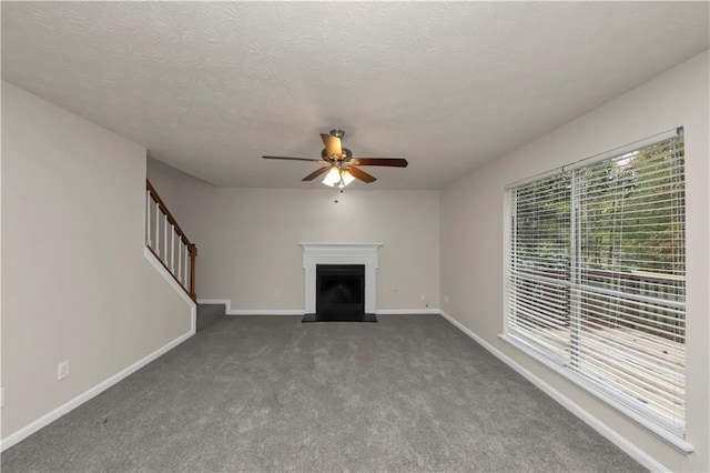 unfurnished living room featuring carpet, a textured ceiling, and ceiling fan