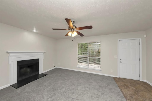 unfurnished living room featuring ceiling fan, carpet floors, and a textured ceiling