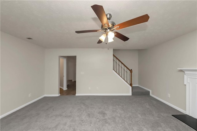 unfurnished living room featuring carpet flooring, a textured ceiling, and ceiling fan