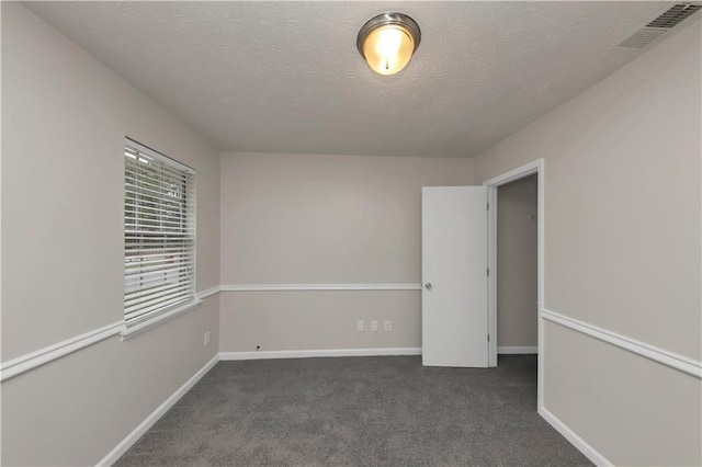 carpeted spare room featuring a textured ceiling