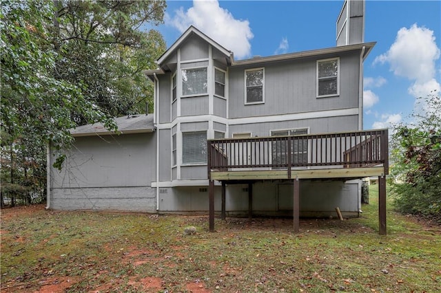 back of property with a lawn and a wooden deck