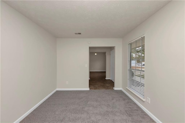 unfurnished room featuring carpet flooring and a textured ceiling