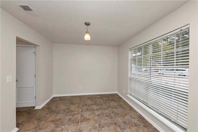 spare room with a textured ceiling