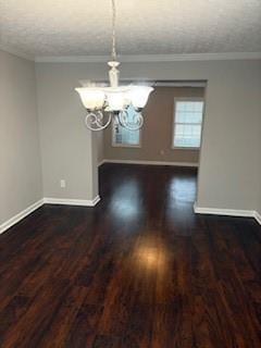 unfurnished dining area with ornamental molding, dark hardwood / wood-style floors, a textured ceiling, and a notable chandelier