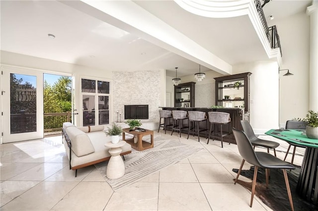 living room with bar, light tile patterned floors, and beamed ceiling