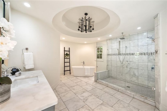 bathroom with shower with separate bathtub, vanity, and a raised ceiling