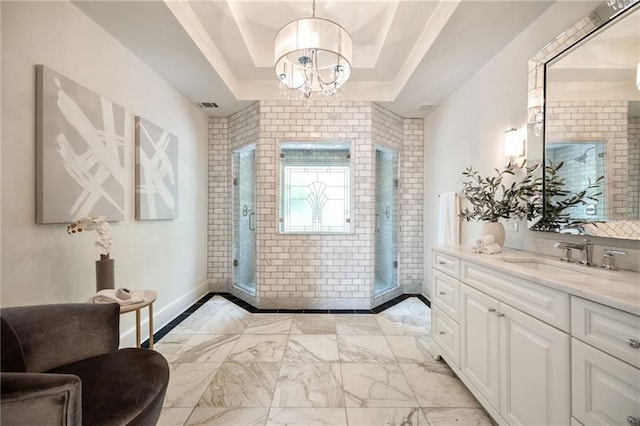 bathroom featuring an inviting chandelier, vanity, a tray ceiling, and a shower with shower door