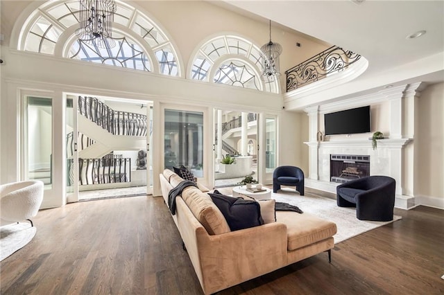 living room featuring a notable chandelier, a high ceiling, and hardwood / wood-style flooring