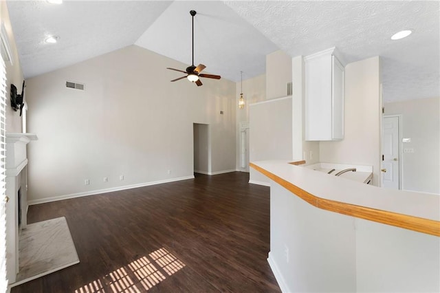 16 Kentucky Walk NE, Cartersville, GA 30121 - unfurnished living room with ceiling fan, a brick fireplace, dark wood-style floors, vaulted ceiling, and baseboards