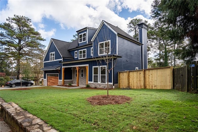 view of front facade featuring a porch, a front yard, and a garage