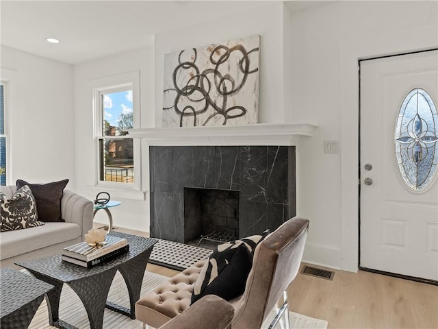 living room with a fireplace and light hardwood / wood-style flooring