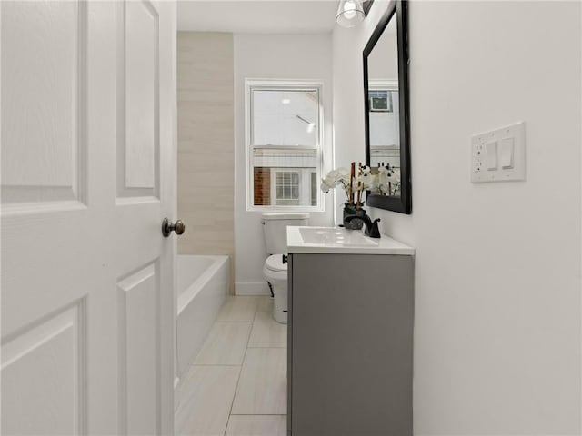 bathroom featuring tile patterned floors, vanity, toilet, and a tub