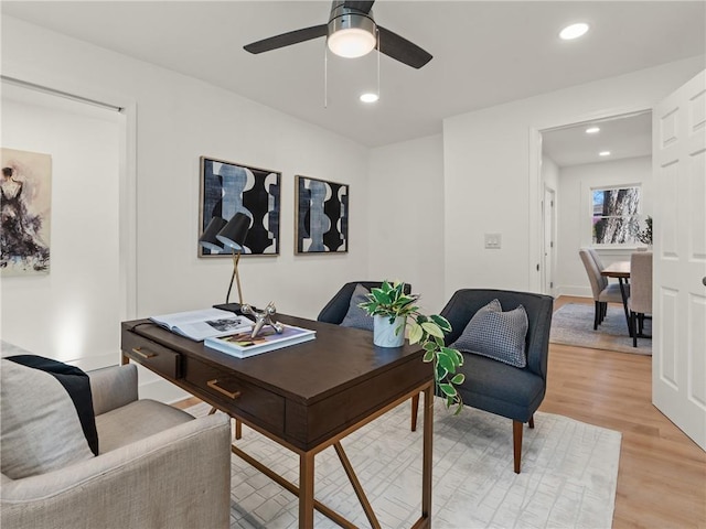 home office with ceiling fan and light hardwood / wood-style flooring