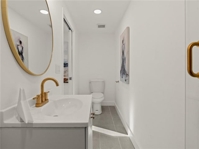 bathroom with tile patterned flooring, vanity, and toilet