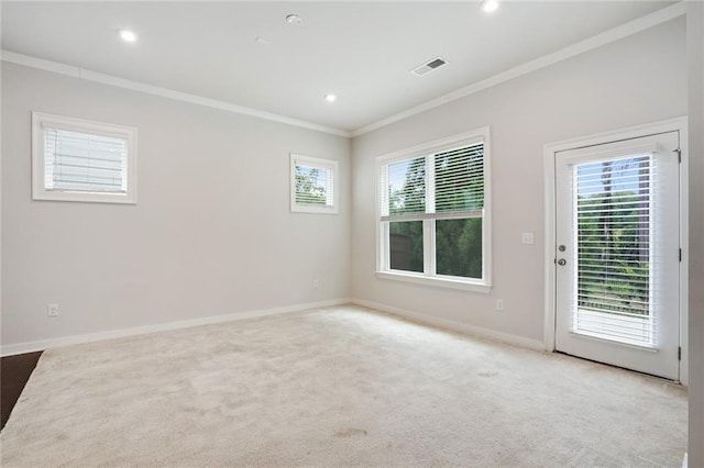 unfurnished room with light carpet, baseboards, visible vents, and crown molding