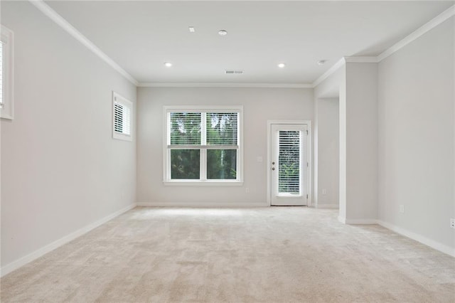 empty room featuring ornamental molding, recessed lighting, light colored carpet, and baseboards