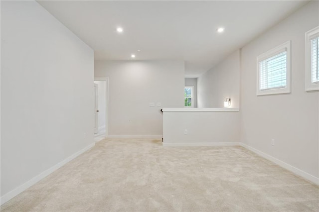 spare room with recessed lighting, light colored carpet, and baseboards