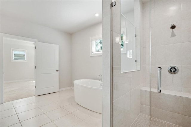 full bathroom featuring a freestanding bath, tile patterned flooring, a shower stall, and baseboards