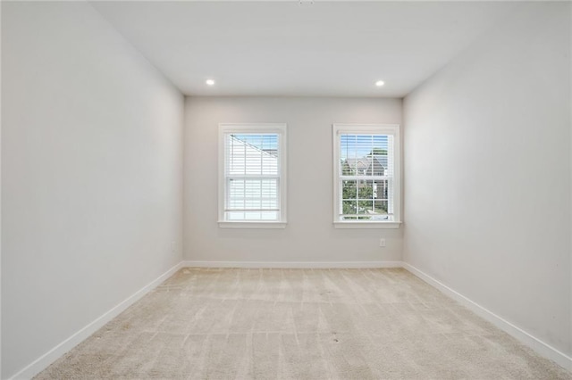 empty room featuring baseboards, recessed lighting, and light colored carpet