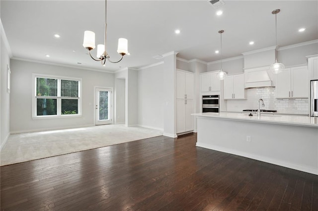 kitchen featuring dark wood-style floors, open floor plan, stainless steel appliances, light countertops, and backsplash