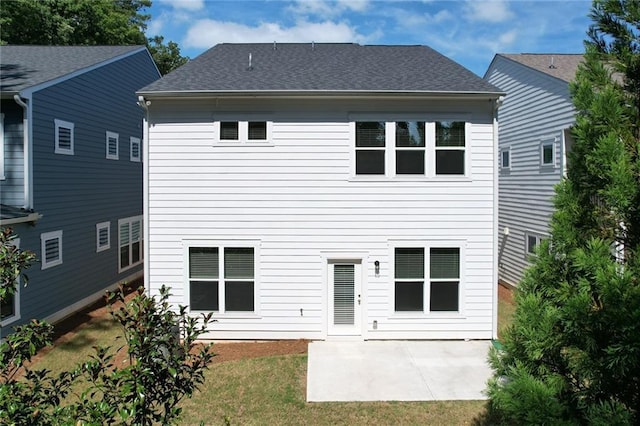 back of house with a patio, a yard, and a shingled roof