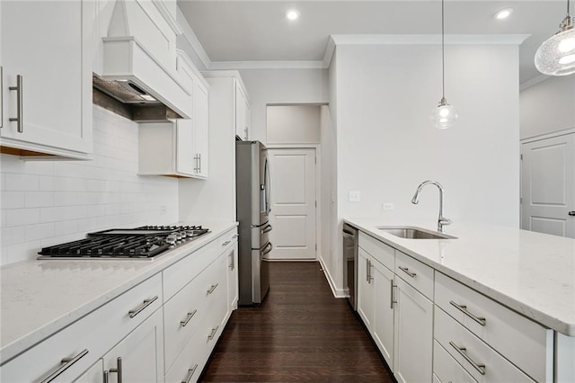 kitchen featuring ornamental molding, appliances with stainless steel finishes, white cabinetry, a sink, and premium range hood