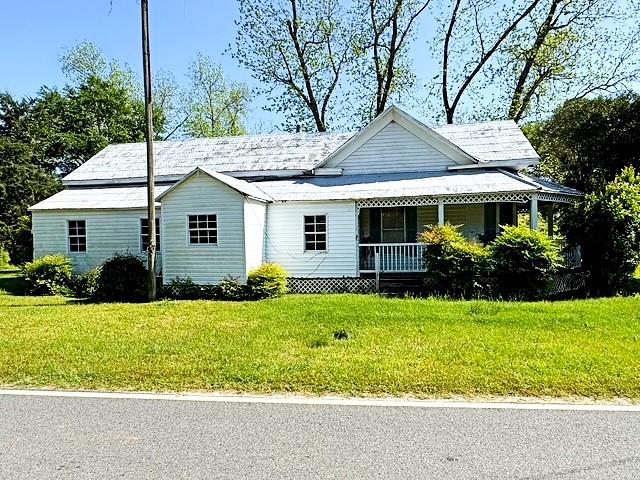view of front of home with a porch and a front yard