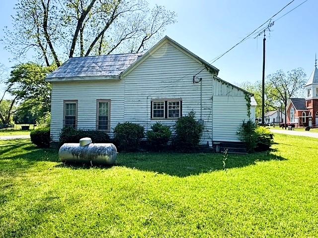 view of side of home with a yard