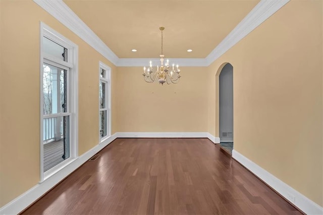 unfurnished dining area with arched walkways, a chandelier, crown molding, and baseboards