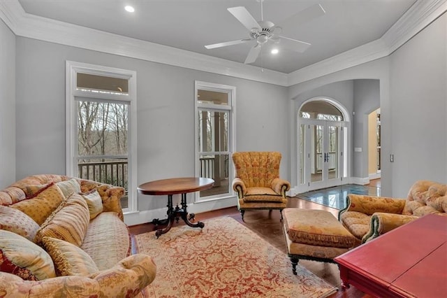 living area with ornamental molding, a ceiling fan, wood finished floors, recessed lighting, and baseboards