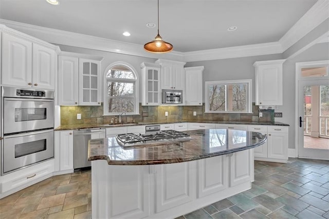 kitchen featuring stone tile floors, white cabinetry, stainless steel appliances, and a sink