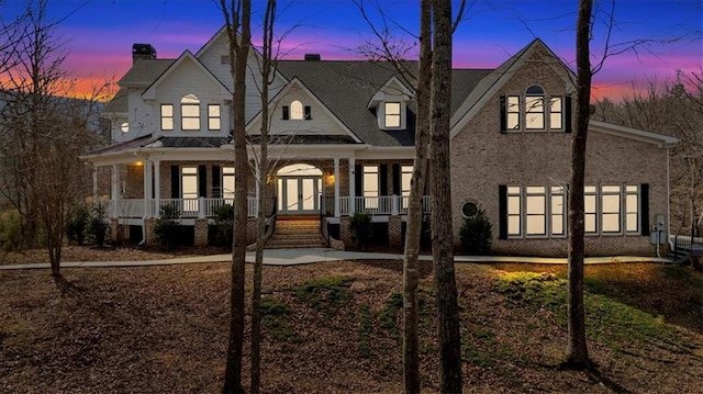 view of front of home featuring brick siding and covered porch