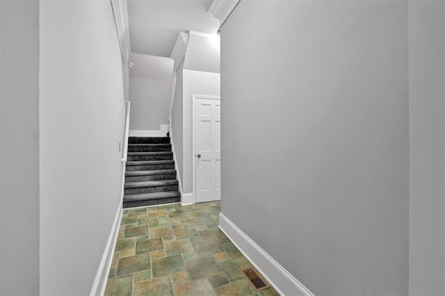 hall featuring visible vents, stone finish floor, stairway, and baseboards