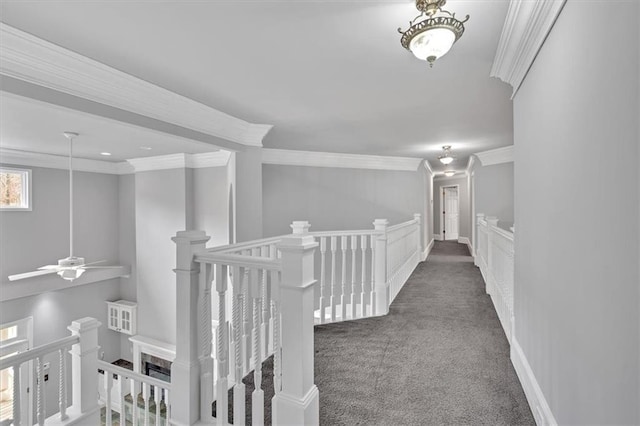 hall featuring baseboards, an upstairs landing, carpet floors, and crown molding