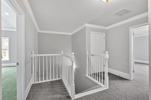 interior space featuring an upstairs landing, visible vents, crown molding, and carpet