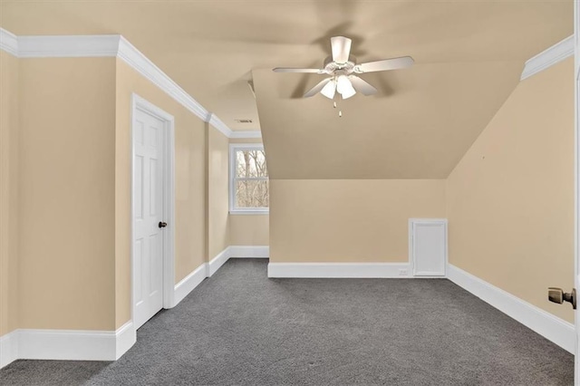 additional living space featuring vaulted ceiling, baseboards, dark colored carpet, and ceiling fan