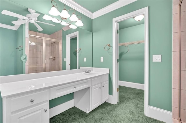 bathroom featuring vanity, crown molding, baseboards, and a stall shower