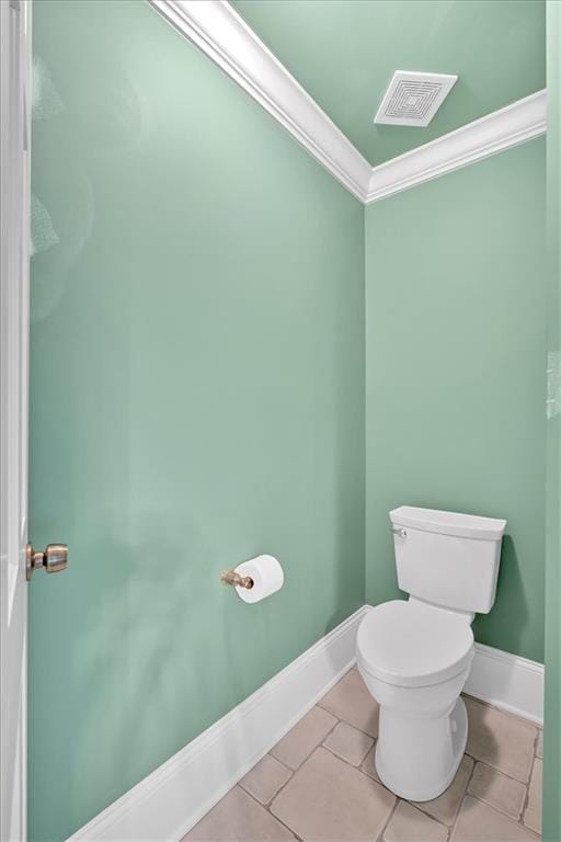 bathroom with tile patterned flooring, crown molding, baseboards, and visible vents