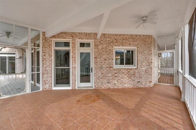 unfurnished sunroom with beamed ceiling and ceiling fan