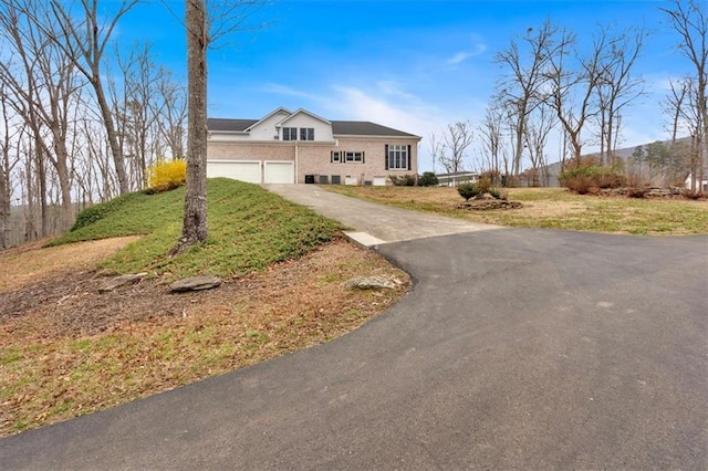 view of front of property with a front lawn, an attached garage, and driveway