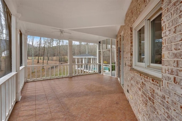 unfurnished sunroom with a ceiling fan