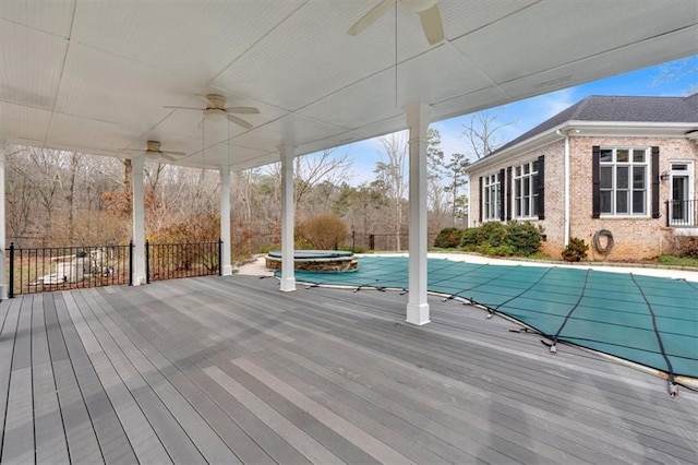 view of swimming pool featuring a covered pool, an in ground hot tub, a wooden deck, and ceiling fan