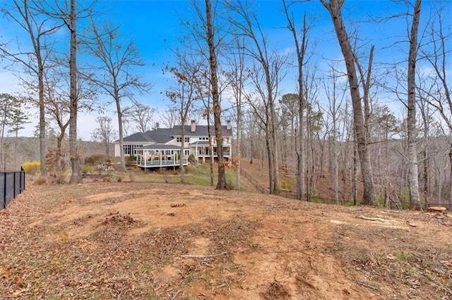 view of yard with a forest view and fence